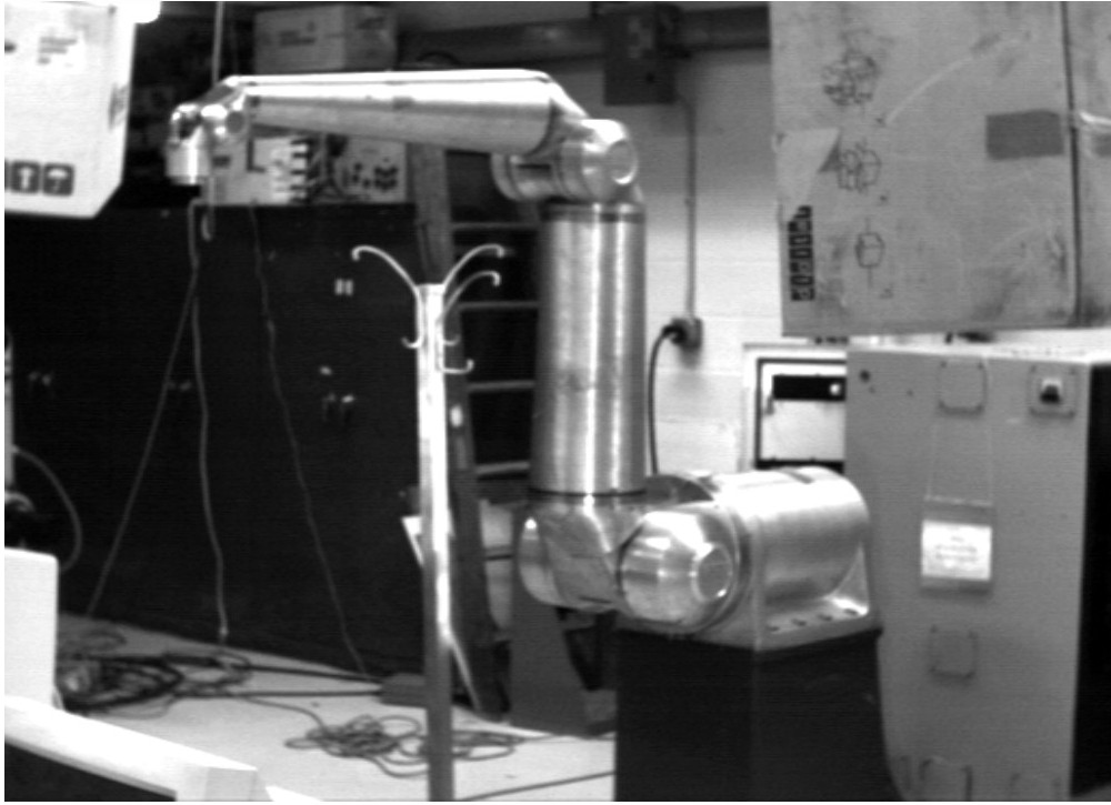 Seven jointed metallic robot surrounded by objects