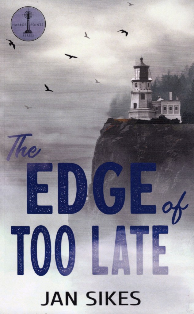 This is the front cover of The Edge of Too Late by Jan Sikes. It shows a cliff with a lighthouse partially hidden by fog.