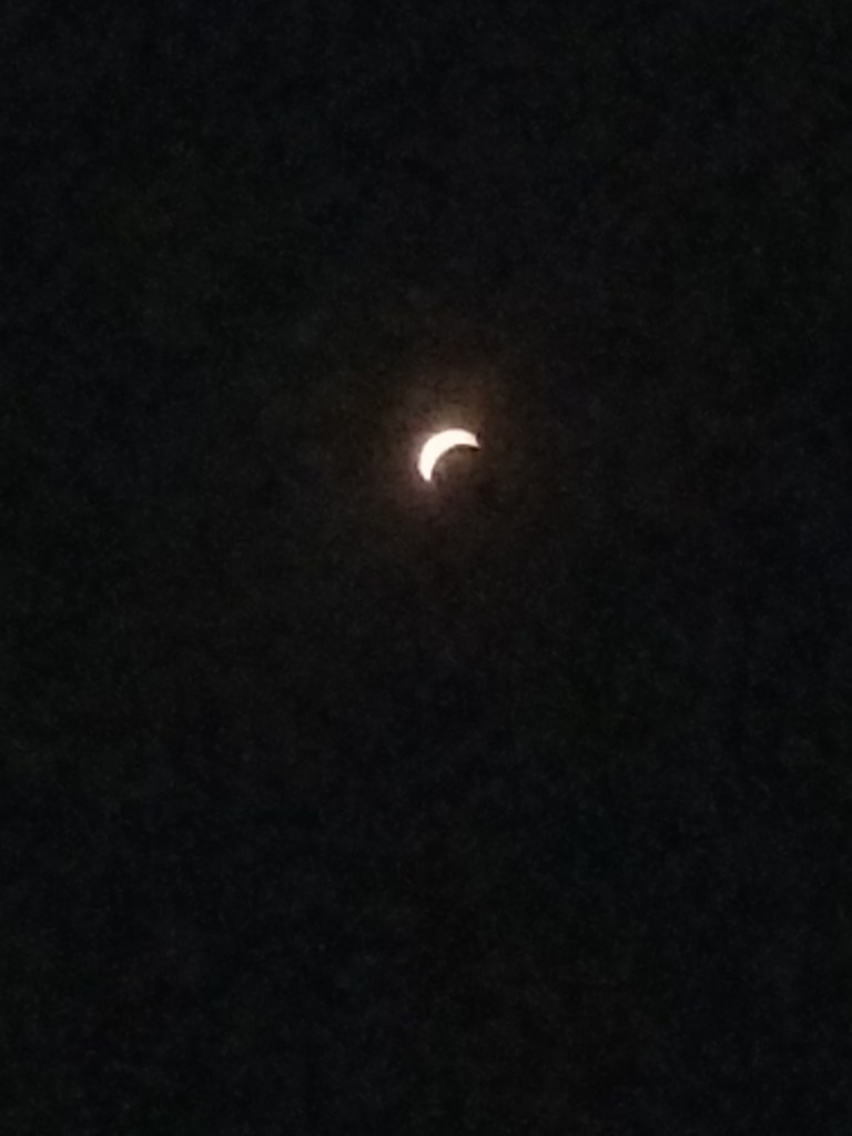 The photo shows a shiny crescent on black background.