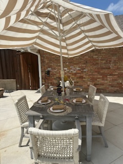 A table set for five with a large parasol.