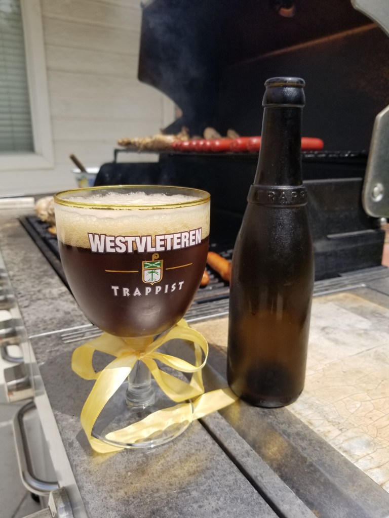 A Westvleteren 12 in front and my open grill in the background.
