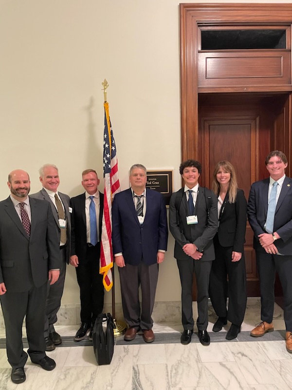 Seven people standing in front of Senator Ted Cruz office.