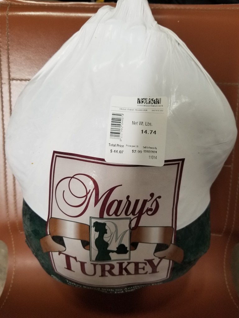 A photo of a frozen turkey wrapped in white plastic.