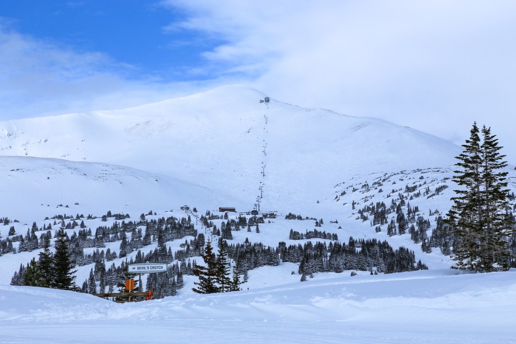 Breckenridge, Colorado / USA January 27, 2020: Imperial Express Lift and the Devil's Crotch Bowl at the top of Breckenridge Ski Resort with snow and a blue sky day.