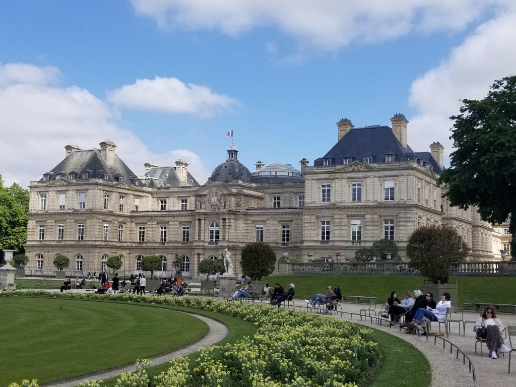 The main building of Jardin Du Luxembourg is a gorgeous building with statues.
