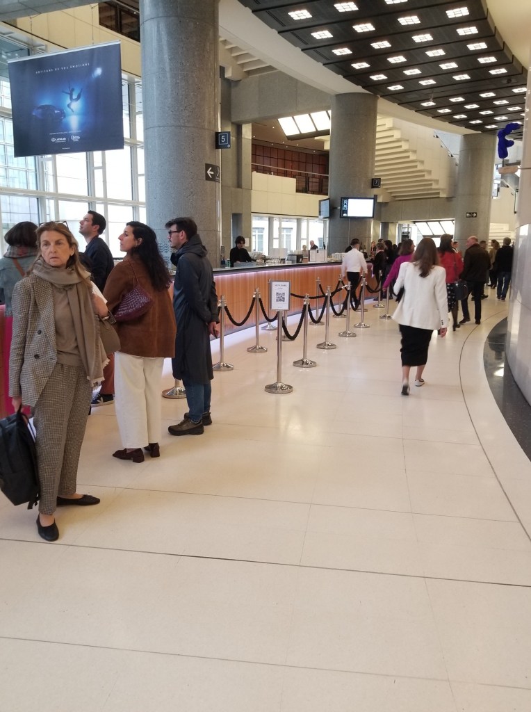 Hallway at Opera at Opera National, Paris, France. There are a few people standing in front of the counters.