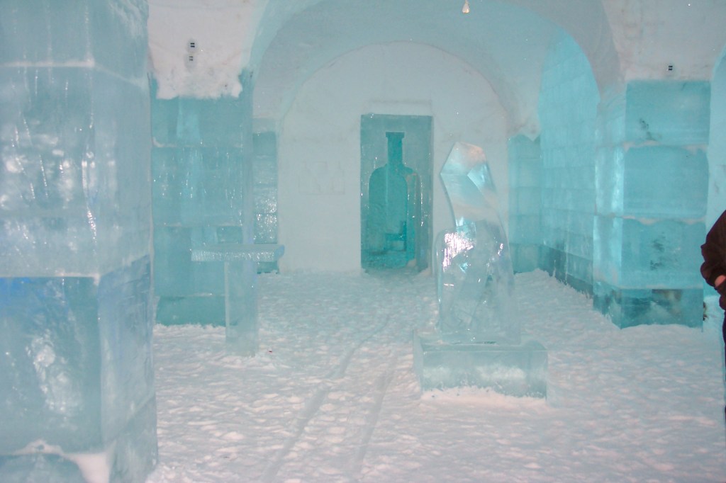 The photo shows an entrance looking like a bottle and there are several pillars and statues made of ice.