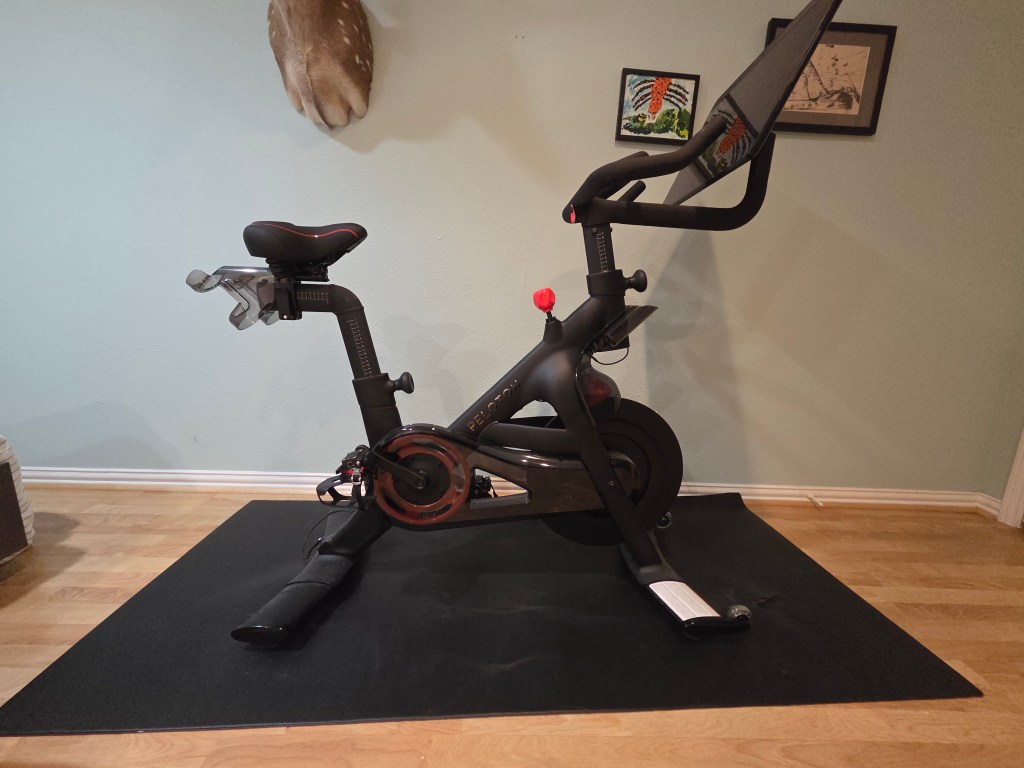 The photo shows a black bike with a large touchscreen.