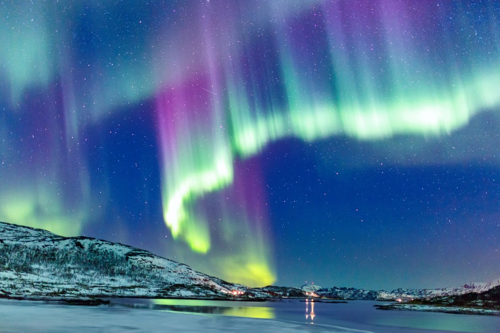 Stunning aurora borealis lights up the night sky with vibrant colors, creating a mesmerizing natural display in the Arctic wilderness.