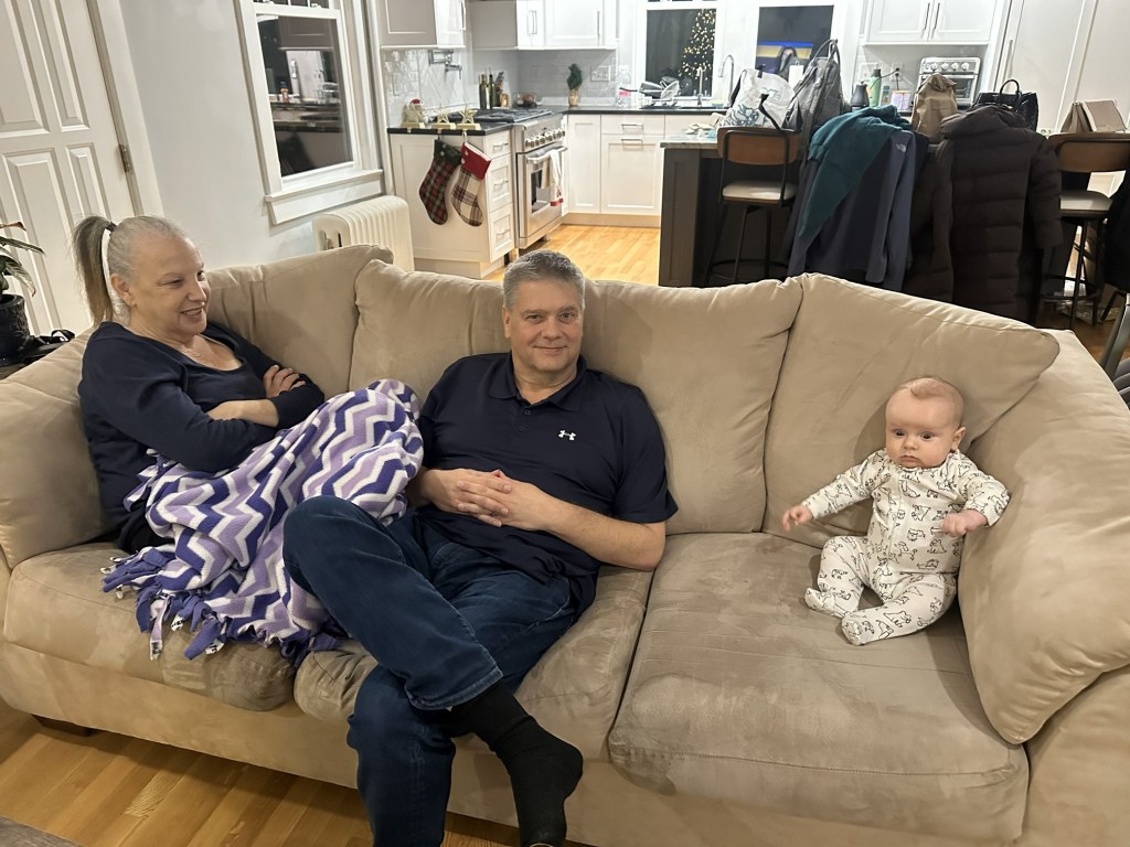 A photo of the three of us sitting in the sofa. Baby Jack is sitting on the right. He is wearing a Pajamas.