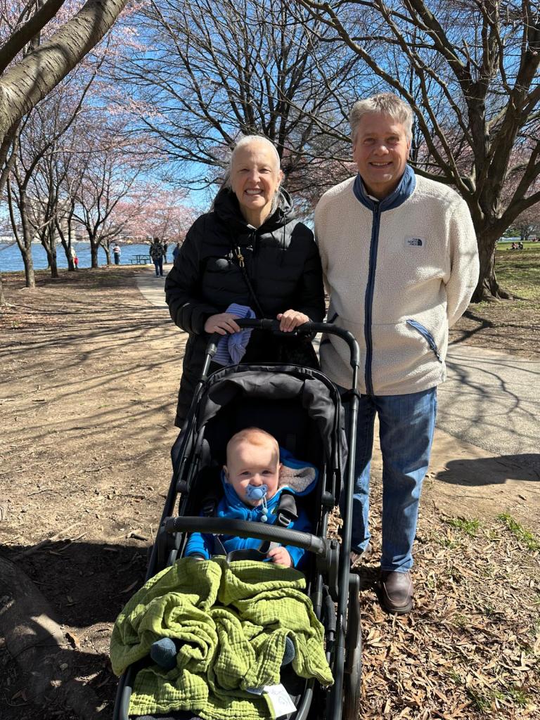 Baby in a stroller my wife and I are standing behind the stroller.