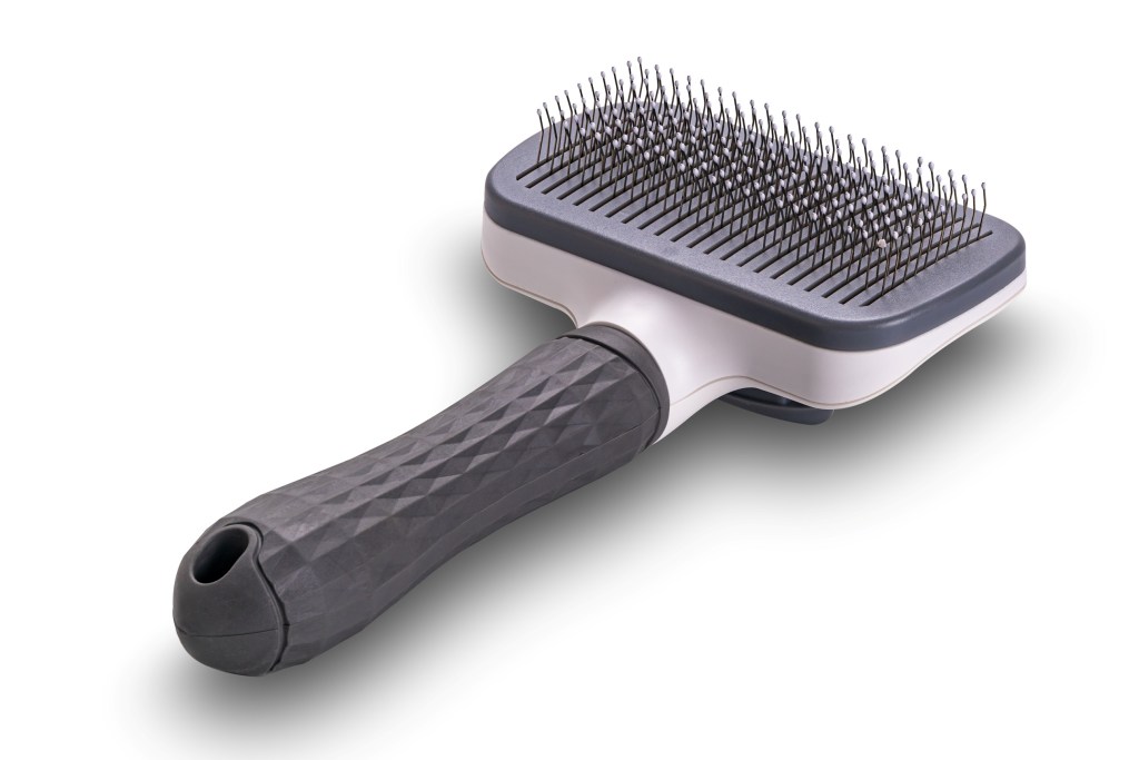 A photo of a slicker brush taken from a high angle view of pet slicker brush isolated on white background with clipping path.