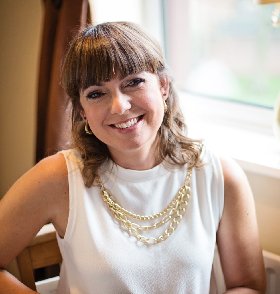 Photo of the author. She is looking into the camera smiling.