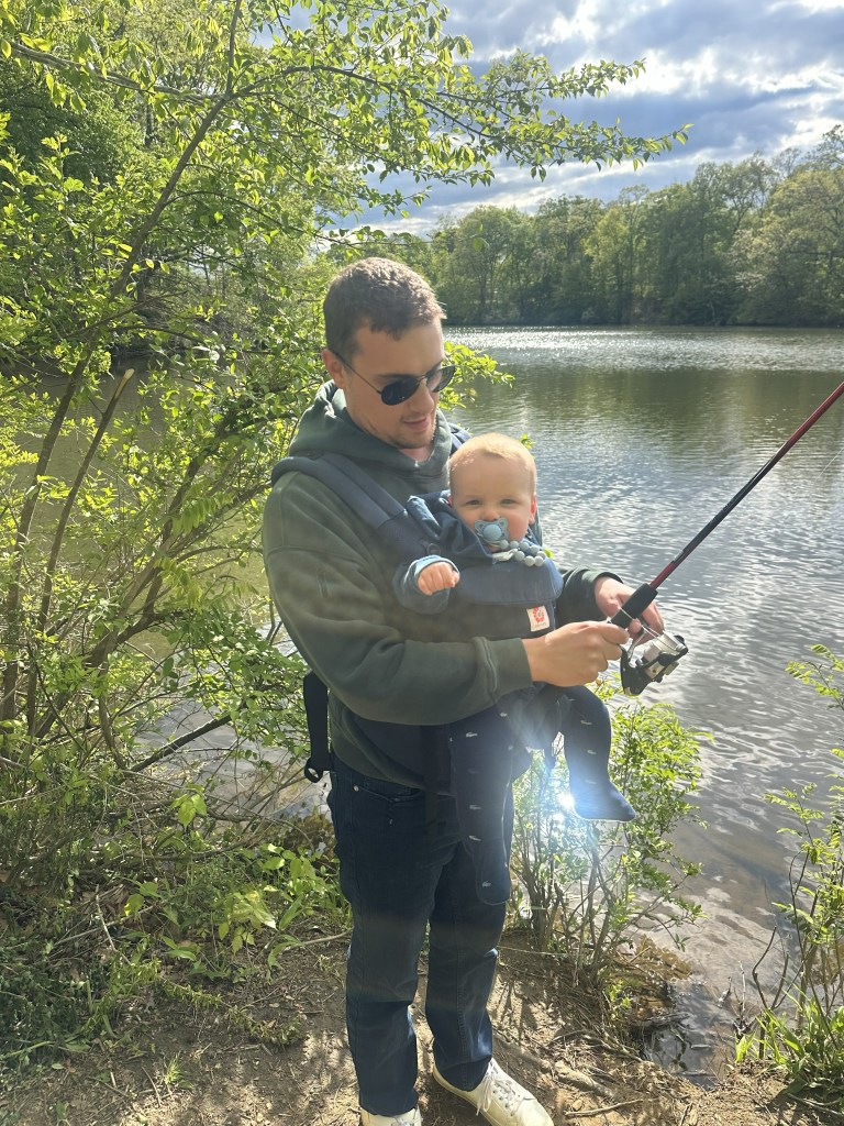 My son Jacob is holding a fishing rod, and Jack is sitting in a baby carrier hanging on Jacob’s front.