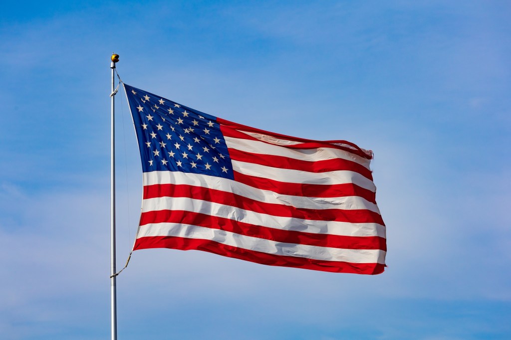 An American flag on the background of a blue sky.
