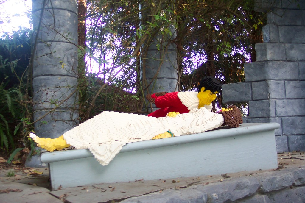 The prince is bending over Sleeping Beauty who is asleep.