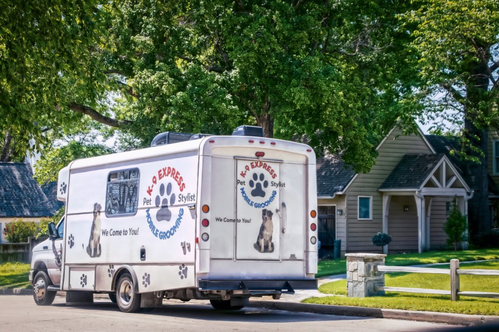 06-30-2022 Tulsa USA - Mobile Dog Wash and Grooming van parked in front of cute house in leafy neighborhood.